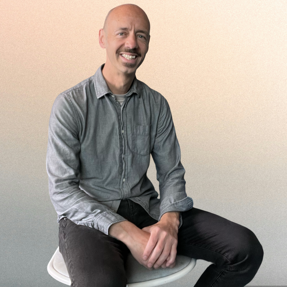 Nick, the person behind Dashboards and Databases, seated and smiling